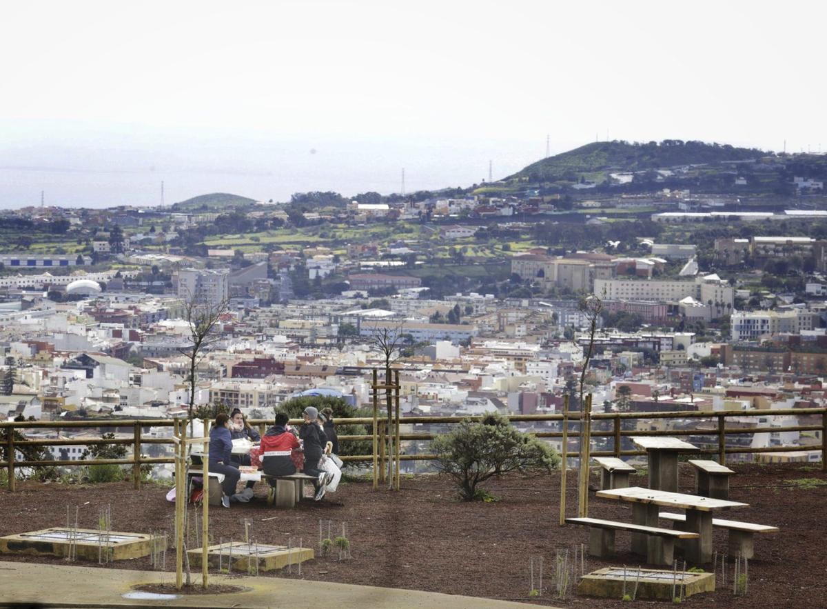 Un grupo de personas en un merendero de la Mesa Mota, con La Laguna de fondo.