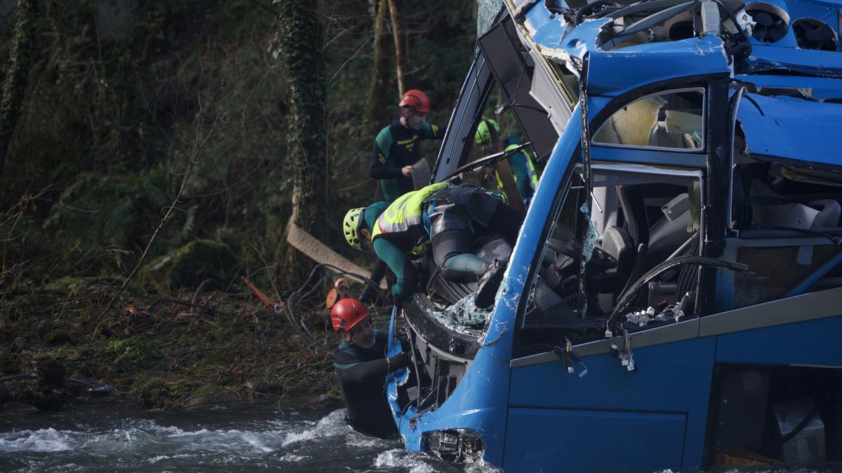 Varios efectivos do Grupo Especial de Actividades Subacuáticas da Garda Civil (GEAS) participan no labor de izado do autobús accidentado.