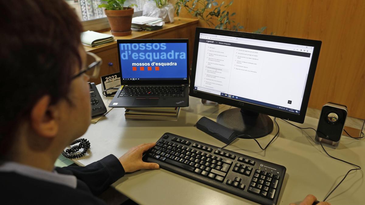 Una agent dels Mossos davant d'un ordinador i tractant un tema d'estafes.
