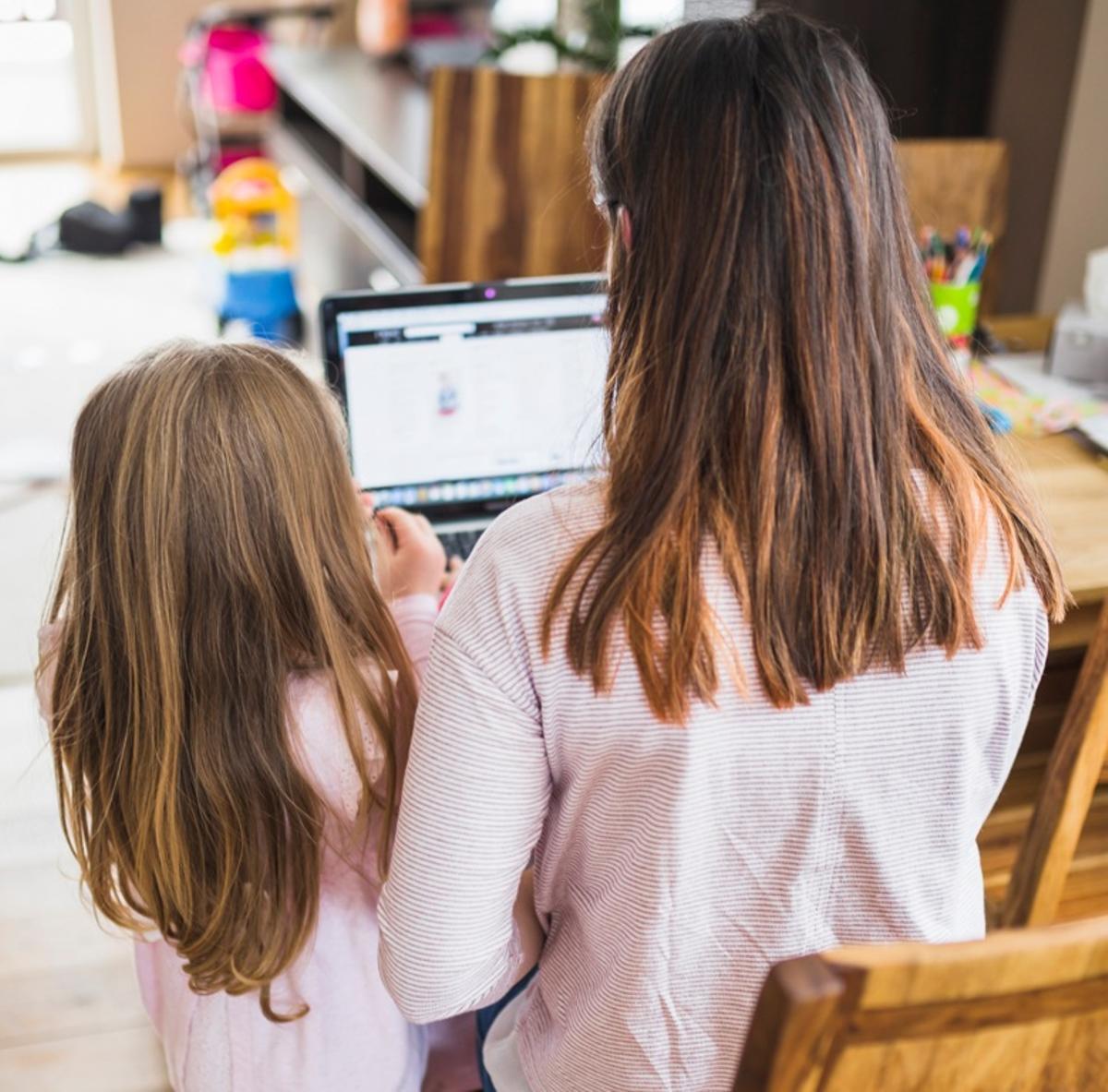 Una madre y una hija consultan una página web.