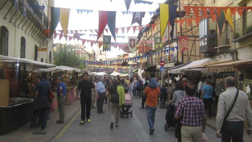 Toresanos y visitantes recorren los puestos del mercado instalados en la calle La Mayor.