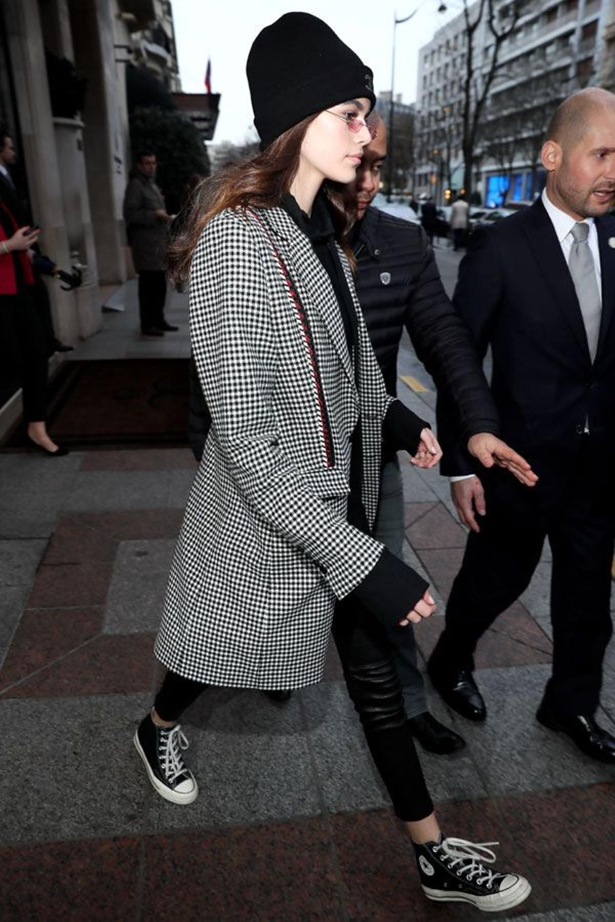 Kaia Gerber con pantalones de cuero, zapatillas Converse y abrigo de pata de gallo