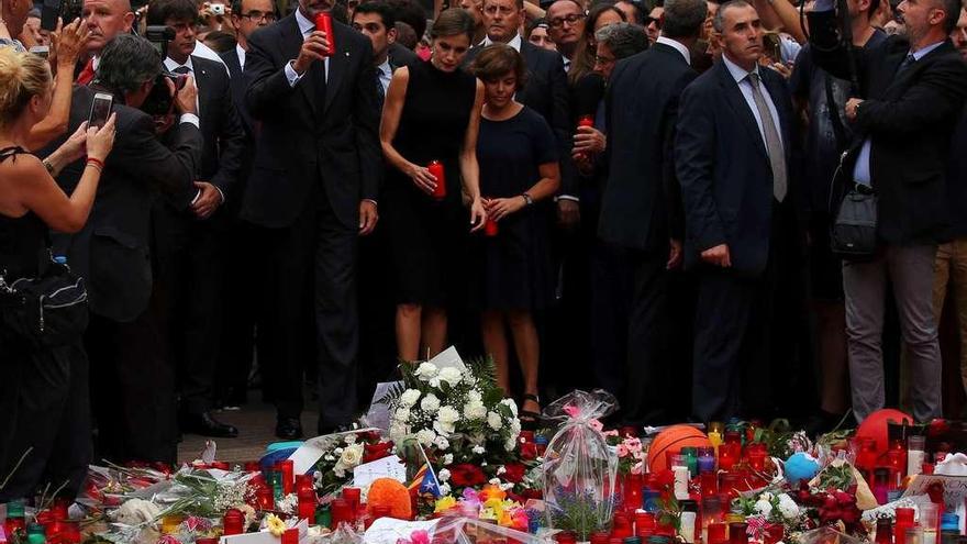 A la izquierda, los Reyes junto a autoridades políticas en las Ramblas, en el punto convertido en zona de homenaje a las víctimas; sobre estas líneas, los monarcas, ayer durante la visita a los heridos.