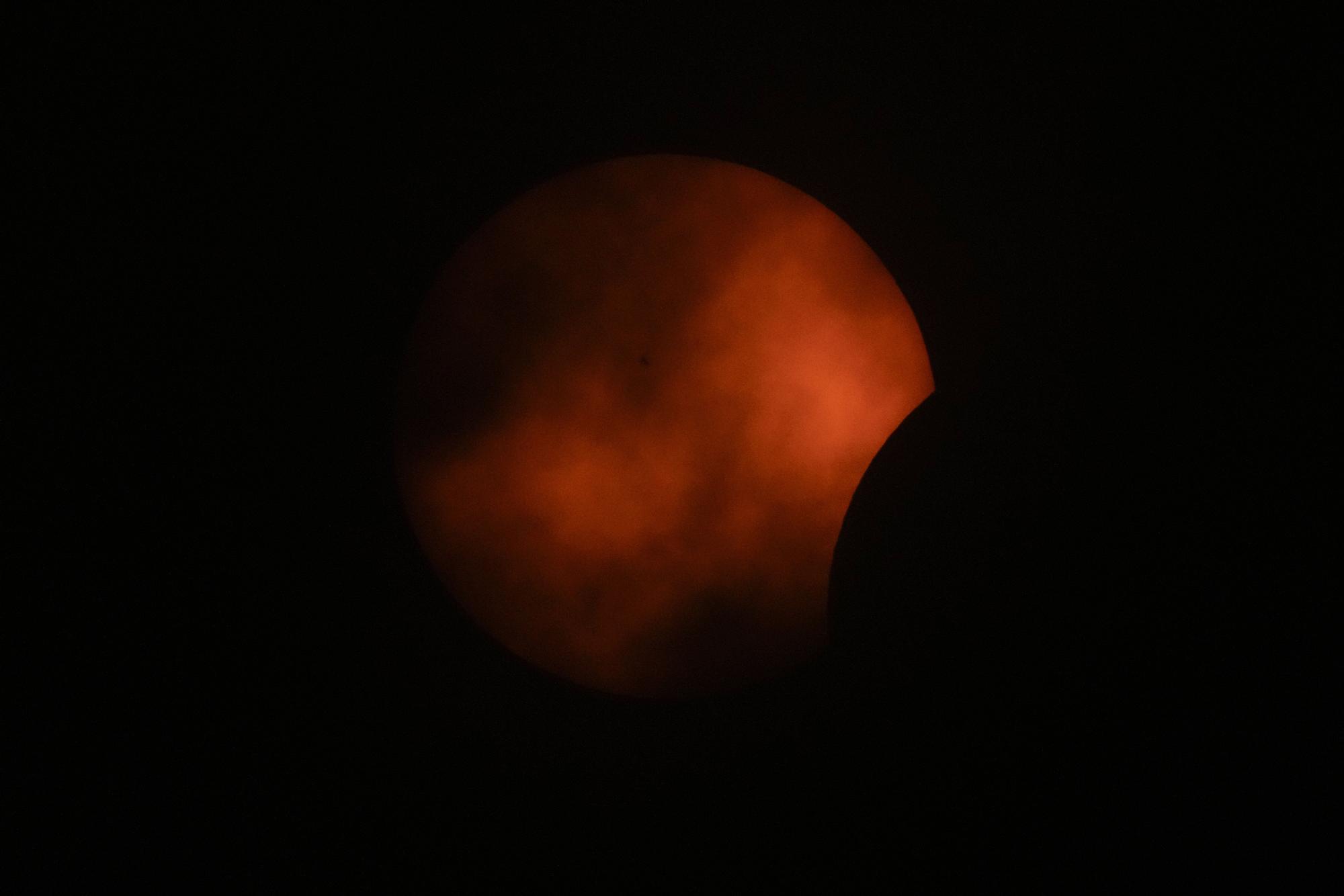 Clouds roll by as the beginning phase of a total solar eclipse is visible from Arlington, Texas, Monday, April 8, 2024. (AP Photo/Julio Cortez) / EDITORIAL USE ONLY/ONLY ITALY AND SPAIN