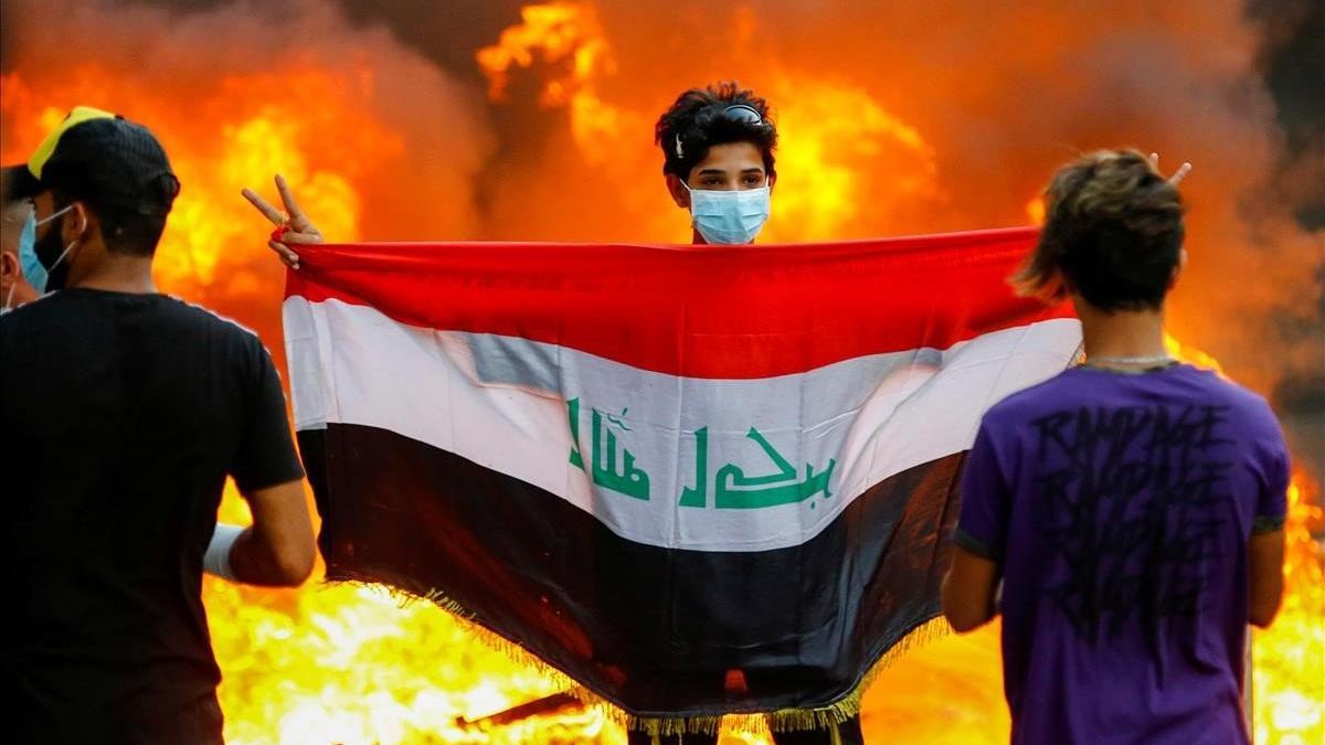 Un manifestante sostiene la bandera iraquí durante unas protestas contra el Gobierno del país, en Bagdad.