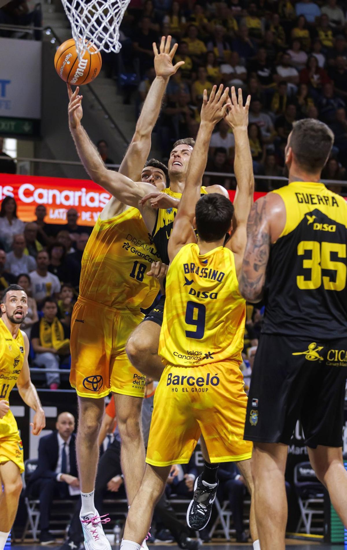 A la izquierda, Abromaitis lanza durante el último derbi jugado en el Santiago Martín. A la derecha –defendido por Salin–, en su primer duelo regional, en 2015. | ACB PHOTO