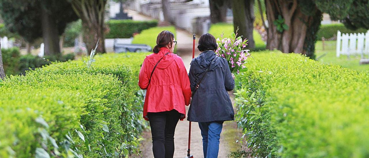 Dos mujeres llevan flores a un ser querido en el cementerio de San Francisco. |   // IÑAKI OSORIO