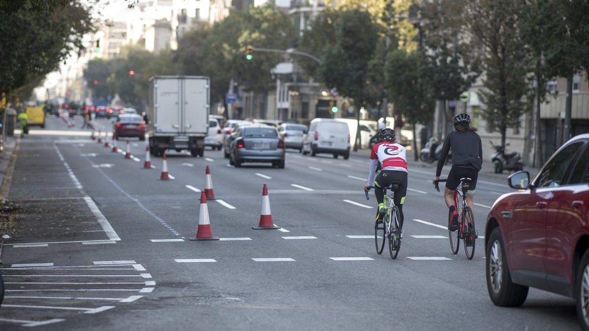 Dos ciclistas pasan junto al carril que se convertirá en carril bici, este sábado en la calle Aragó.