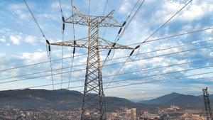 Una torre de transporte de energía perteneciente a red eléctrica, con la ciudad de Bilbao al fondo.