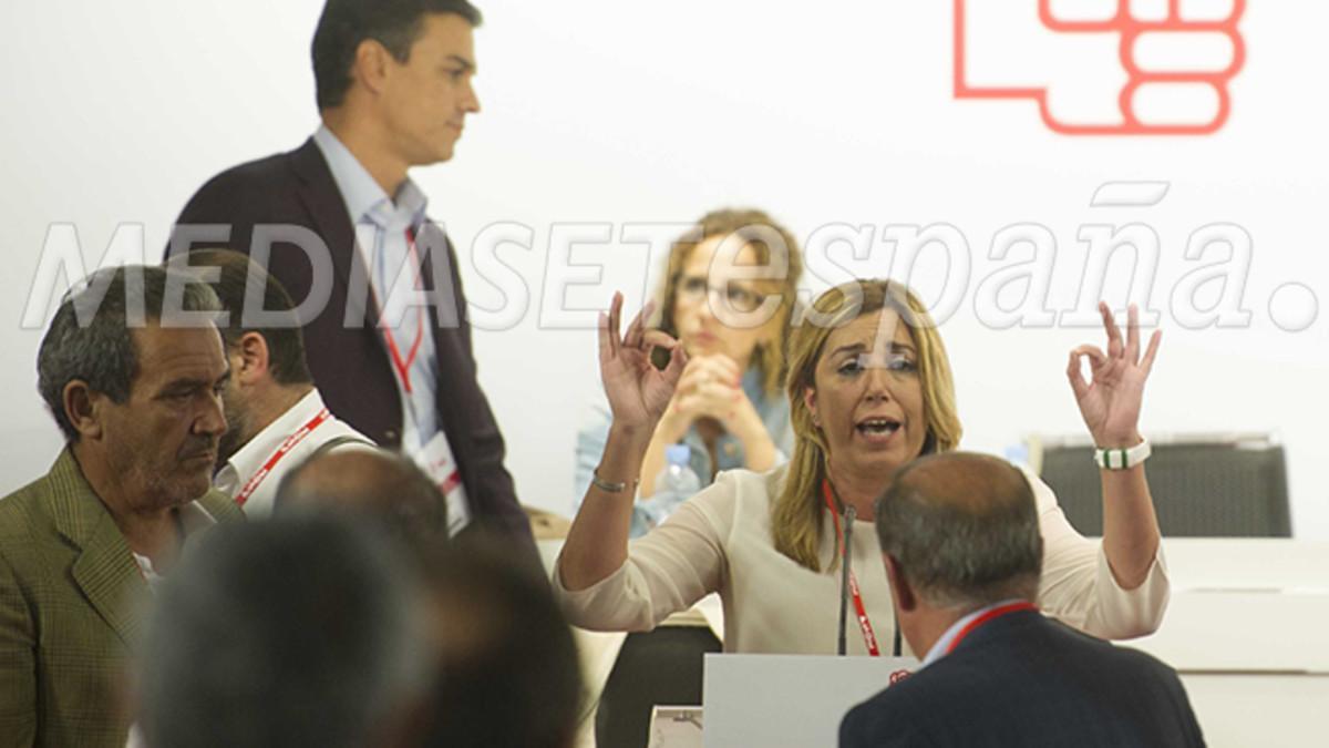 Susana Díaz toma la palabra, mientras pasa por detrás suyo Pedro Sánchez.