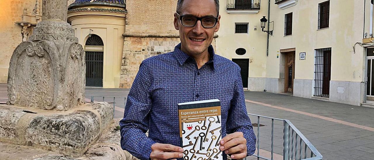 José Miguel Martínez Castelló, con el libro, delante de la iglesia de la Asunción de Torrent. | S. COBOS