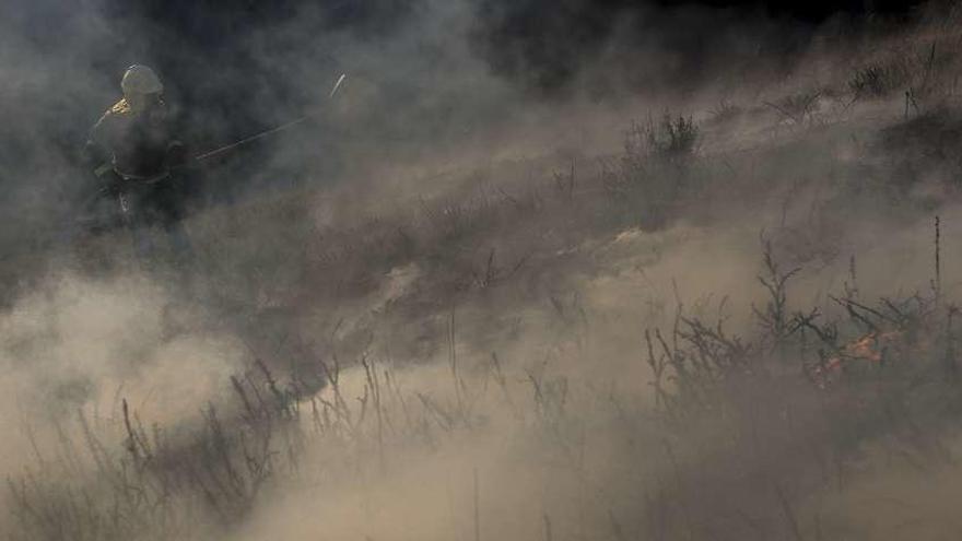 Un efectivo de la lucha contra los incendios combate el fuego de Padrenda. // Brais Lorenzo