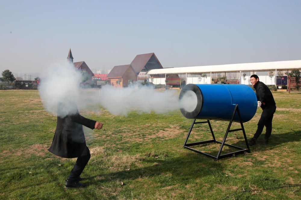 Dos jóvenes prueban un cañón de niebla casero que lanza humo hecho de agua y alquitrán para recordar la importancia de proteger el medioambiente.