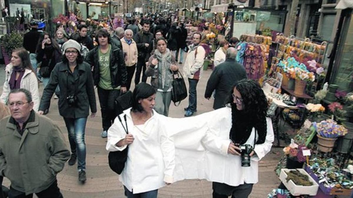 María de los Ángeles, y la fotógrafa Judit Taberna, del proyecto 'Yo seré tus ojos', en la Rambla.