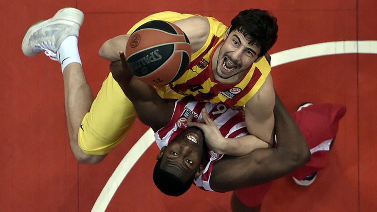 Tomic y Dunston pelean por un balón, durante el tercer partido de los cuartos de la Euroliga, disputado entre el Barça y el Olympiacos en Atenas