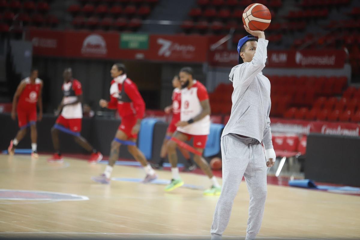 Bell-Haynes, vestido de calle, lanza un tiro libre a una mano mientras sus compañeros realizan ejercicios al fondo, ayer en el entrenamiento del Casademont.
