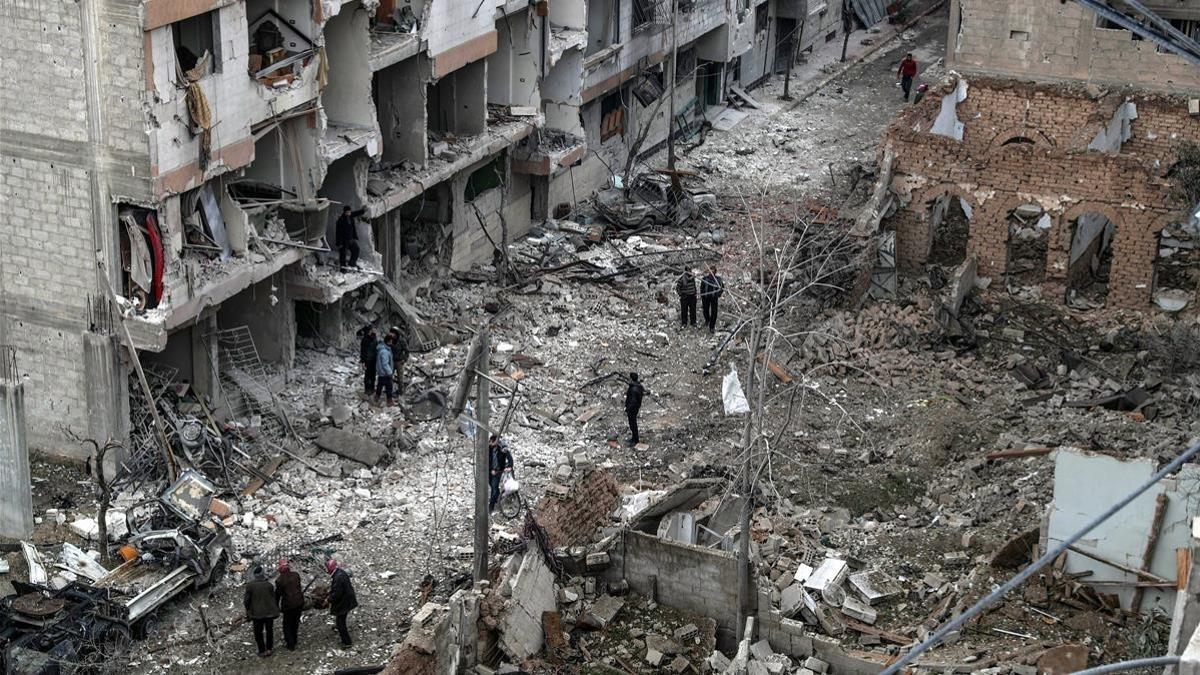 Vecinos inspeccionan los edificios en ruinas tras varios bombardeos el día anterior en Duma, feudo rebelde de Guta Oriental (Siria), el 22 de febrero.