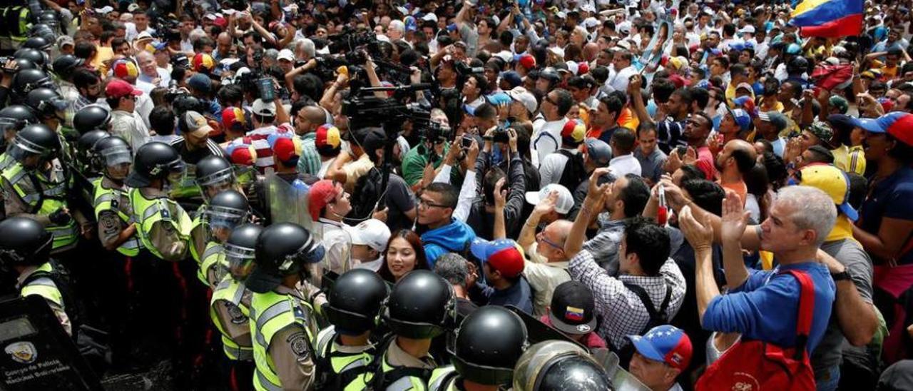 La Policía trata de contener a los manifestantes que protestaban ayer en Caracas.