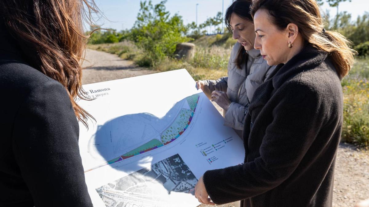 La alcaldesa Natalia Chueca mira el mapa con la ubicación de una nueva zona verde en Zaragoza.