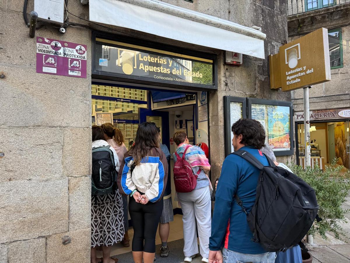 Turistas y peregrinos comprando lotería a primera hora de la mañana en Porta Faxeira