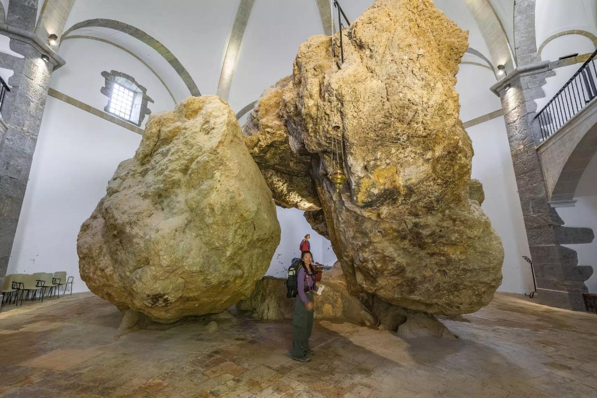 Pasando por debajo de los dólmenes en la ermita de San Miguel de Arretxinaga.