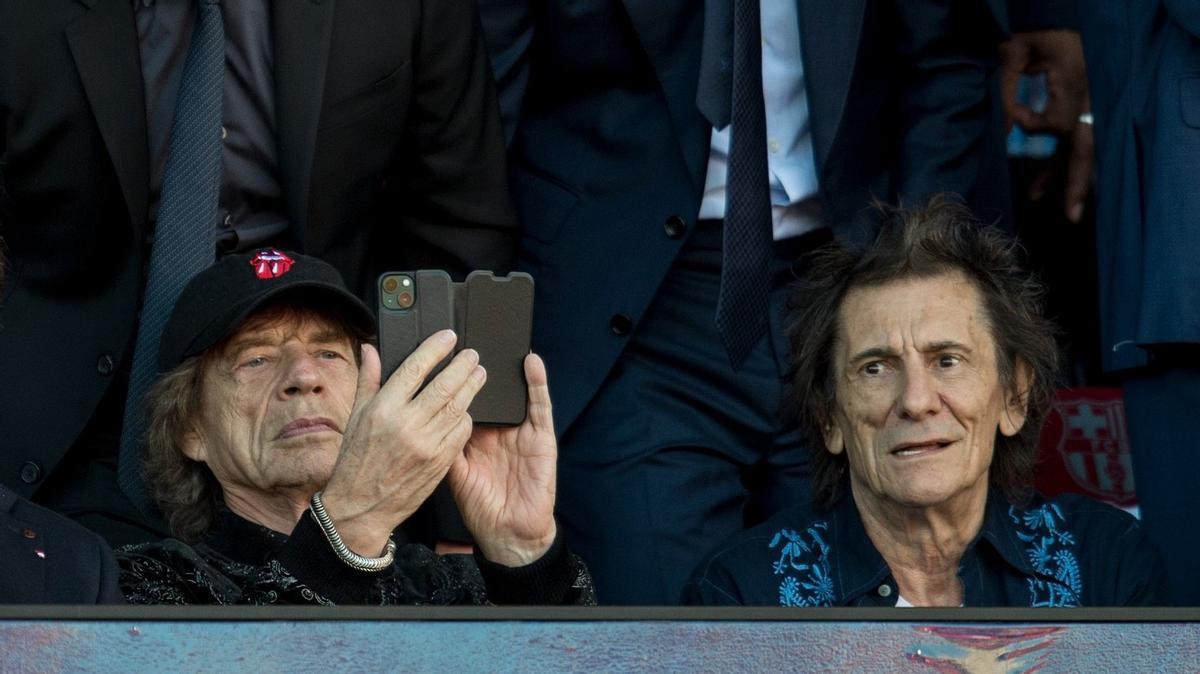 Mick Jagger graba con dos móviles, con Ron Wood, a su lado, durante el clásico.