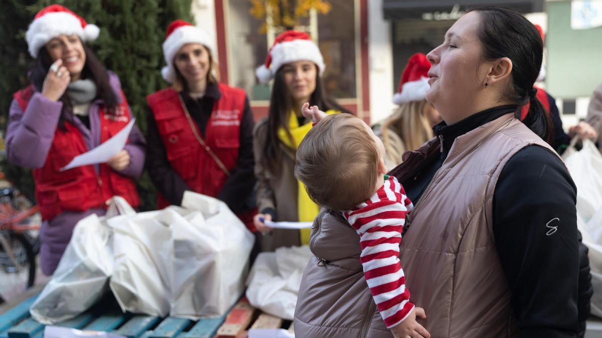 Una refugiada ucraniana pasa con su hijo junto a un puesto navideño en MadriD.