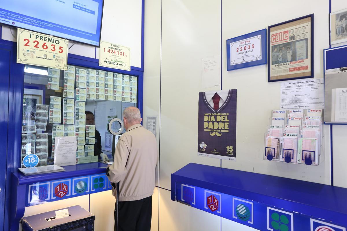 Archivo - Un hombre compra lotería en una Administración de Lotería, archivo