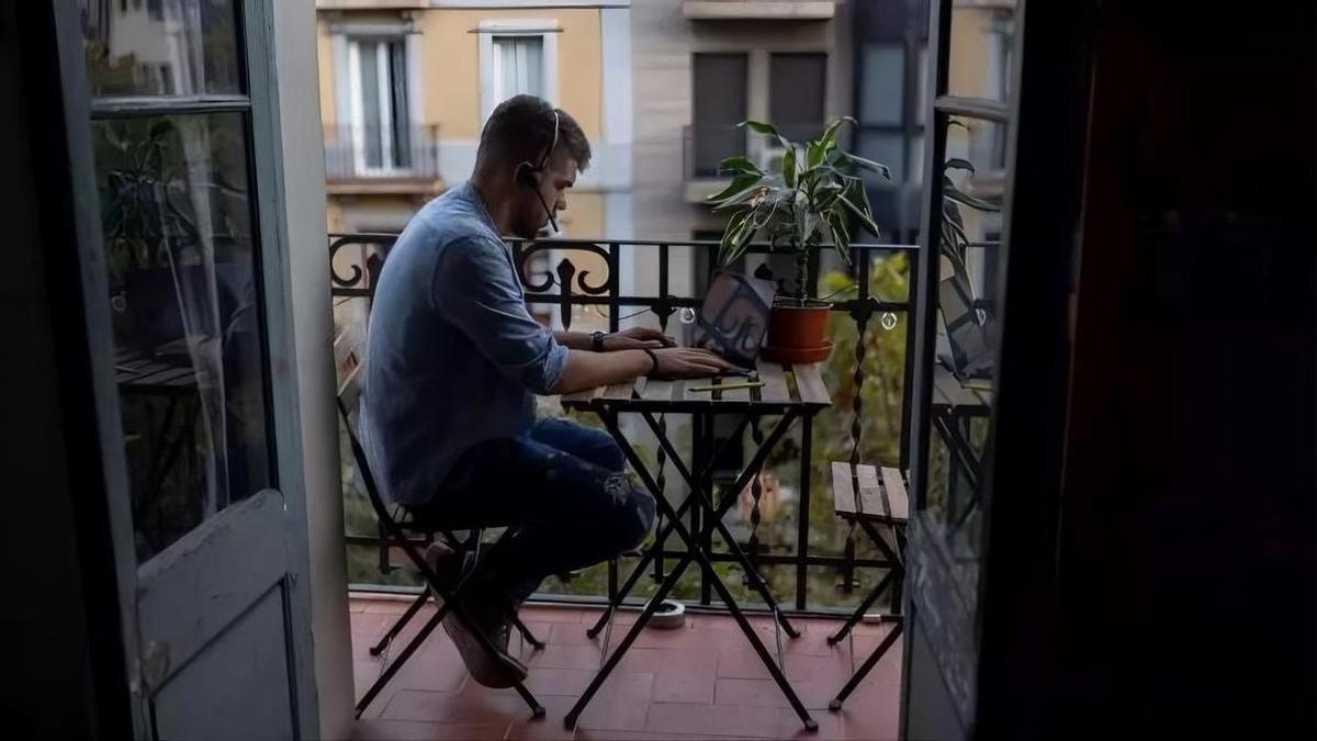 Un home teletreballa des de la terrassa del seu domicili