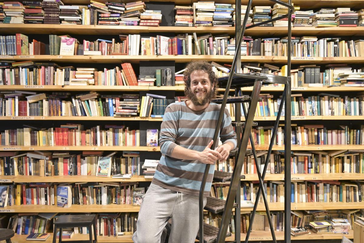 El propietario de A Tobeira de Oza, junto a la escalera que emplea para colocar los libros.