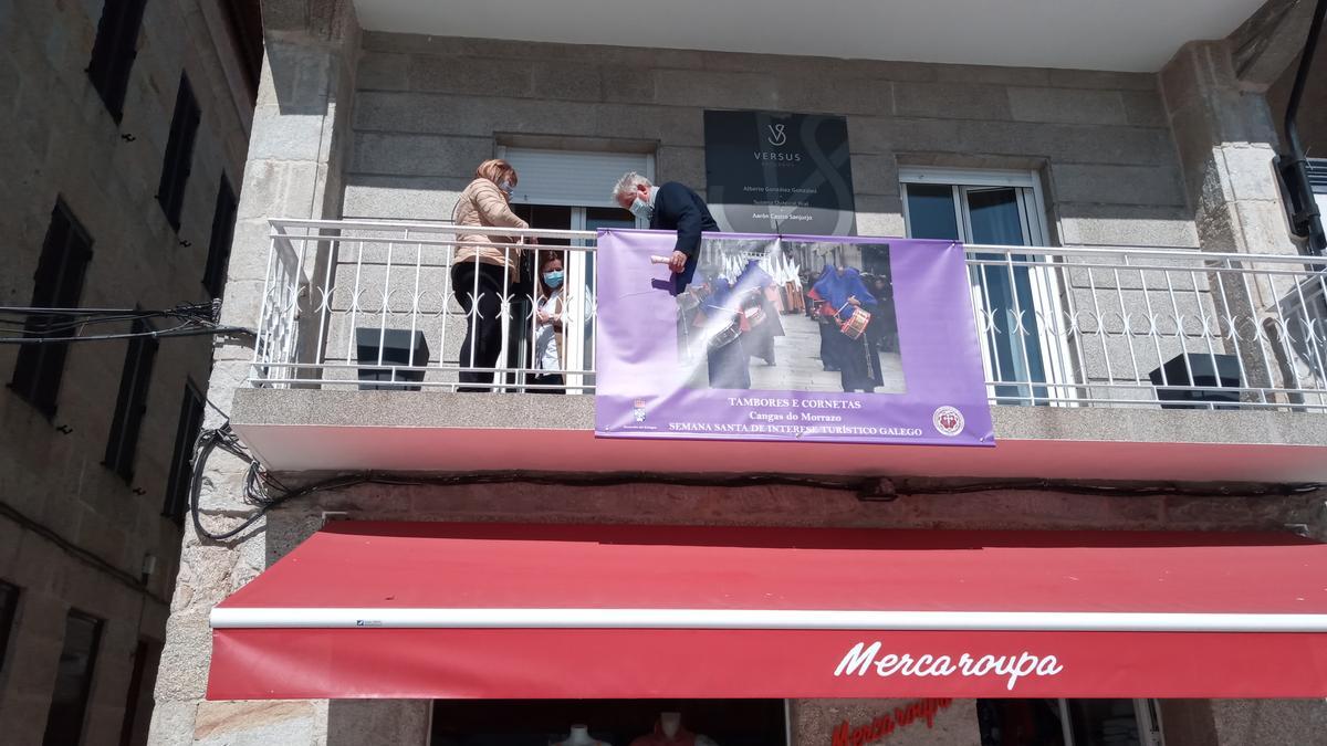 El presidente de la Coordinadora de Semana Santa, Manuel Gil, colocando un cartel en una casa.