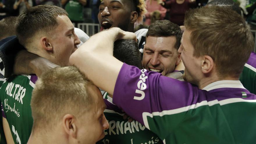 Los jugadores del Unicaja se abrazan en el centro de la pista tras lograr la victoria el domingo ante el Real Madrid.