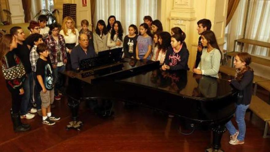 Integrantes de los nuevos coros de &#039;Peques&#039; y Juvenil de la Fundación Coral Casablanca ensayan en torno al piano que toca su director, Óscar Villar.  //Ricardo Grobas