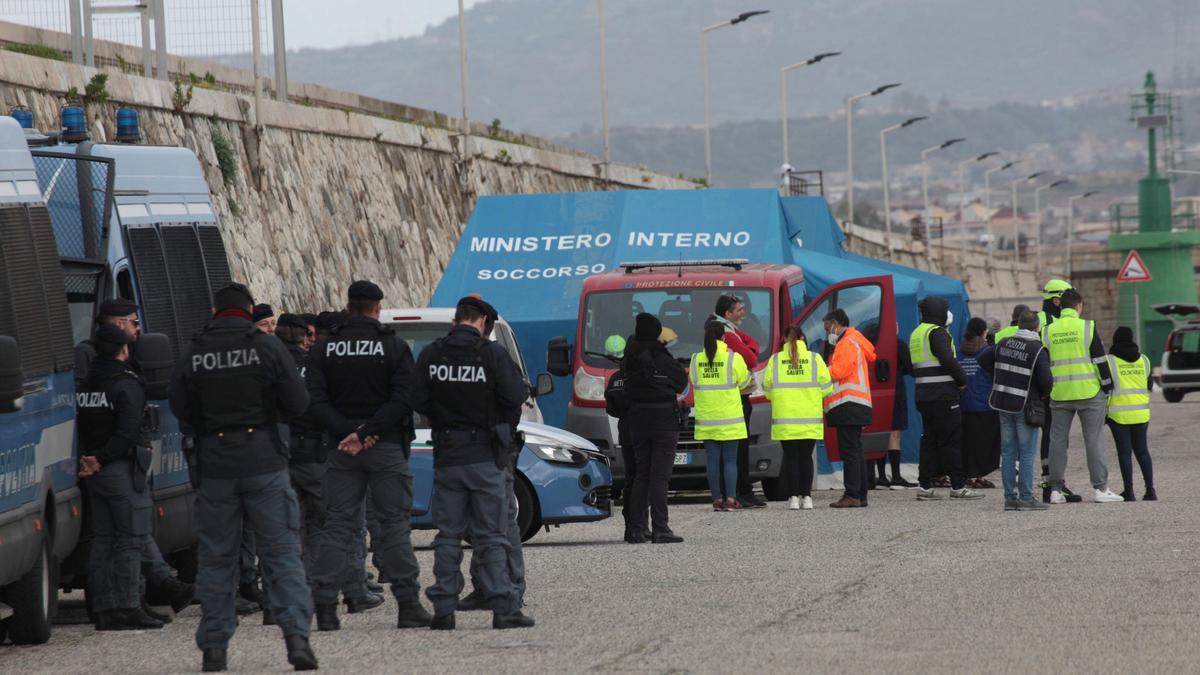 Reggio Calabria (Italia). Agentes de la policía italiana atienden a inmigrantes rescatados en el Mediterráneo este sábado en las costas del país,  EFE/EPA/MARCO COSTANTINO