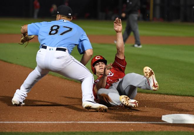 Scott Schebler # 43 de los Rojos de Cincinnati se desliza de manera segura a la tercera base mientras Bobby Honeyman # 87 de los Marineros de Seattle espera la pelota durante la cuarta entrada de un juego de entrenamiento de primavera en el Estadio