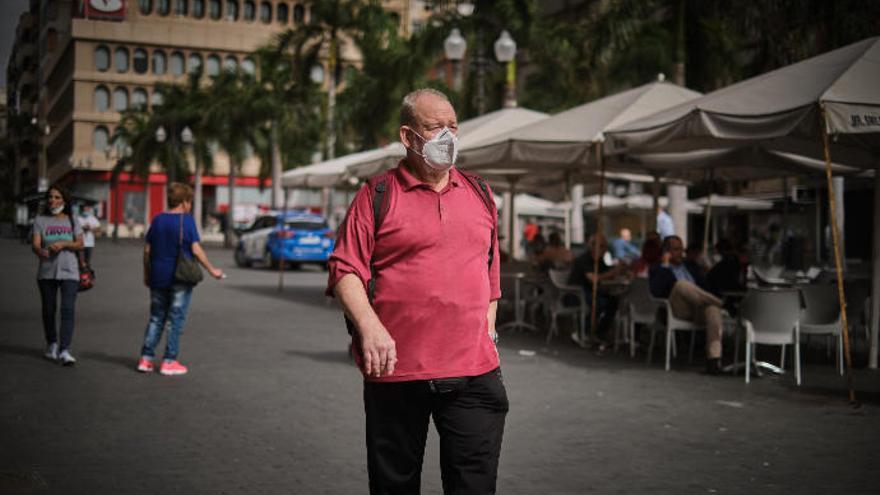 Un hombre pasea por Santa Cruz con su mascarilla.