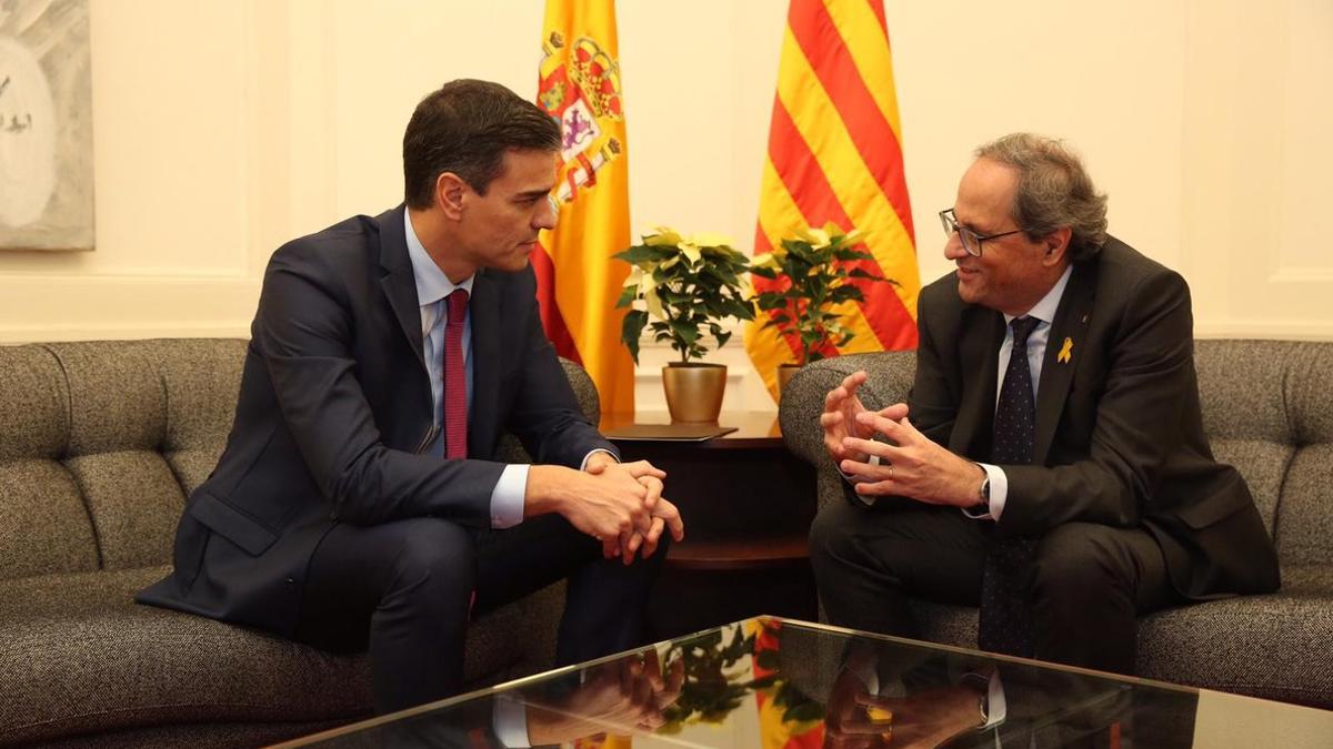 inicio de la reunión entre los presidentes del Gobierno y de la Generalitat, había dos flores de Pascua amarillas en la mesita de detrás.