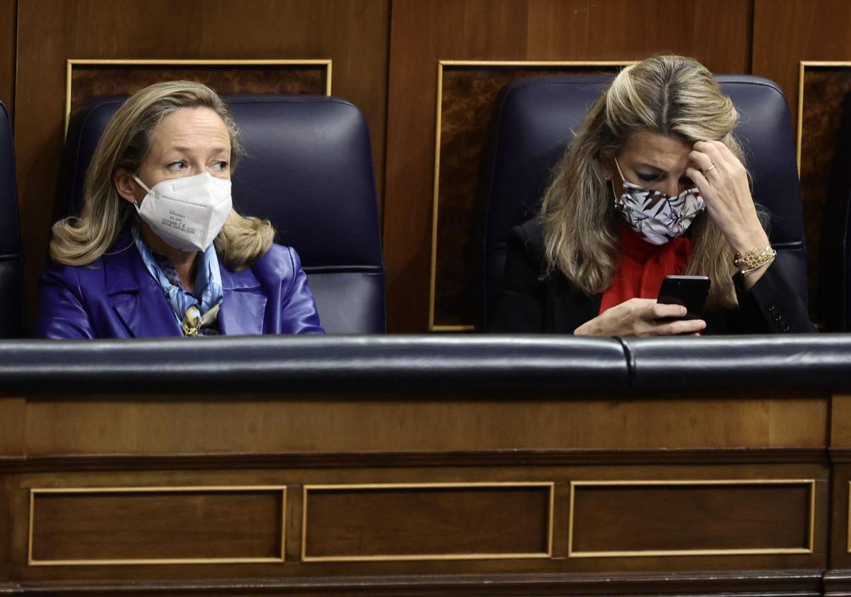 La vicepresidenta primera y ministra de Asuntos Económicos, Nadia Calviño (i); la vicepresidenta segunda del Gobierno y ministra de Trabajo y Economía Social, Yolanda Díaz, en una sesión plenaria en el Congreso de los Diputados.