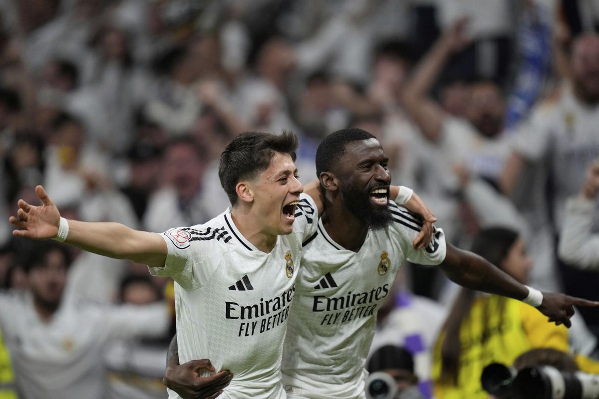 Real Madrid's Arda Guler, left, and Real Madrid's Antonio Rudiger celebrate after a fourth goal in extra time during the Spanish Copa del Rey semifinal second leg soccer match between Real Madrid and and Real Sociedad in Madrid, Spain Tuesday, April 1, 2025. (AP Photo/Bernat Armangue)