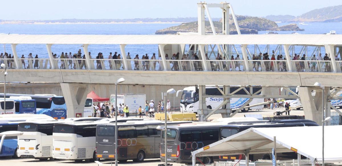 Decenas de turistas, recién desembarcados, se dirigen hacia la estación marítima por uno de los ‘fingers’. | J. A. RIERA