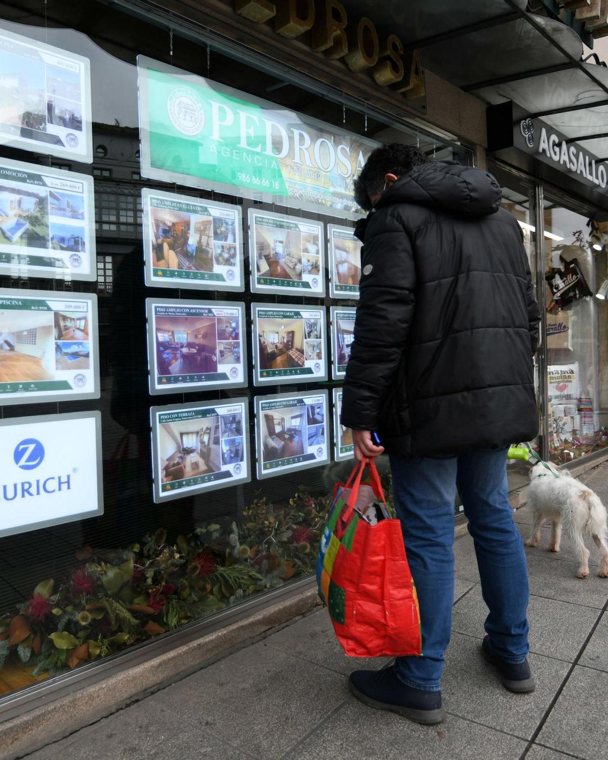 Un hombre mirando los carteles de una inmobiliaria pontevedresa. | // GUSTAVO SANTOS