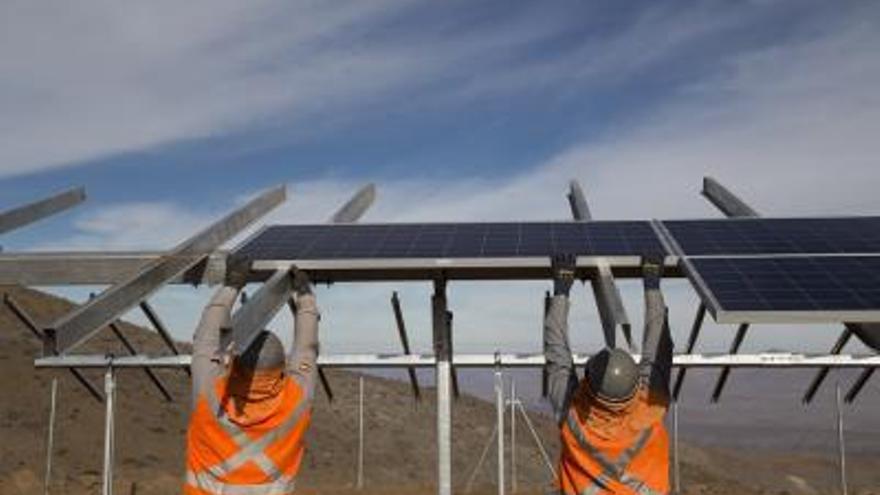 Dos operarios de Soltec
montando un parque
fotovoltaico.  // FDV