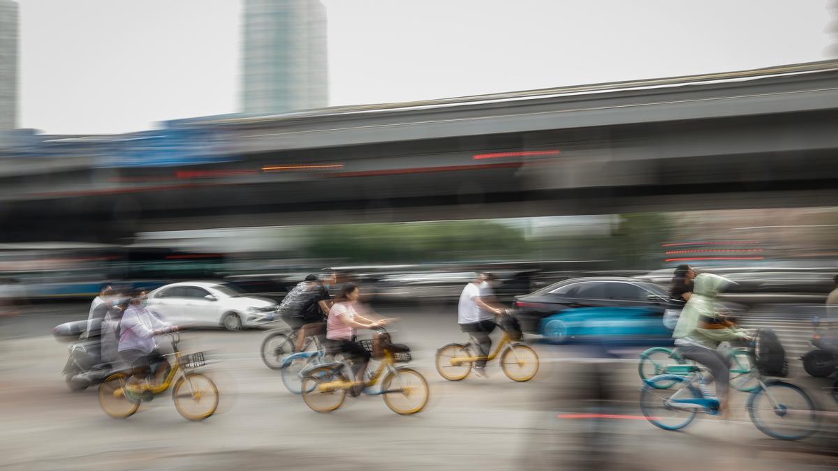 Personas montan en bicicleta en el distrito de Chaoyang, en Pekín.