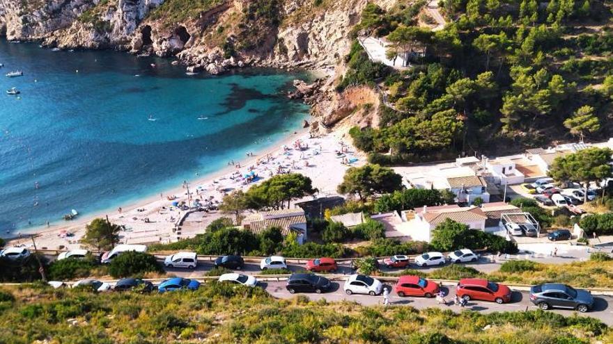 Imagen tomada a las 10 de la mañana del domingo de la cala y de los coches aparcados. | A. P. F.