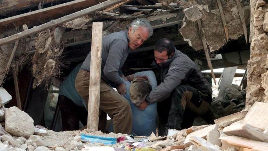 Miembros de los servicios de rescate logran sacar a una mujer herida que quedó atrapada bajo los escombros de su casa en Onna.