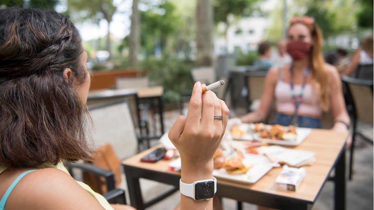 Una mujer fuma en una terraza de Barcelona.