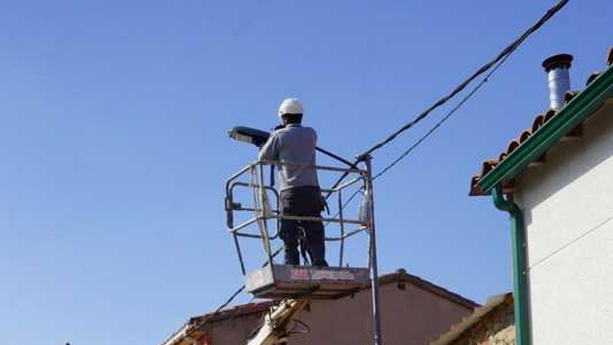 Un trabajador procede la instalación de nuevas farolas en un pueblo alistano.