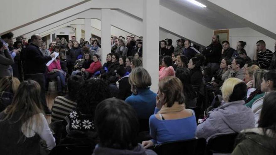 Reunión de los padres del colegio Carmen Ruiz-Tilve, ayer, en el centro social de El Cortijo.