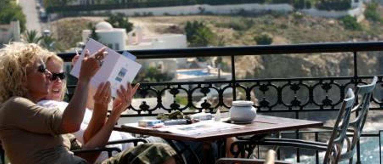 Una pareja de turistas consulta un folleto en la terraza del hotel Montíboli en La Vila.