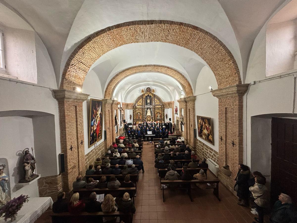 Vecinos disfrutan de la actuación de la coral en la iglesia del pueblo.